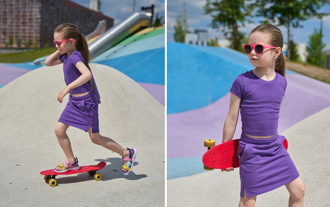 Девочка со скейтом в руках на спортивной площадке.
