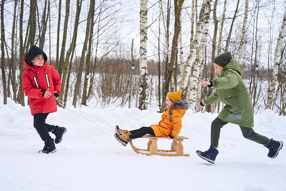 Дети зимой катаются на санках.