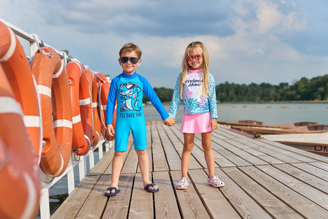 Мальчик c девочкой в купальниках на фоне озера.
