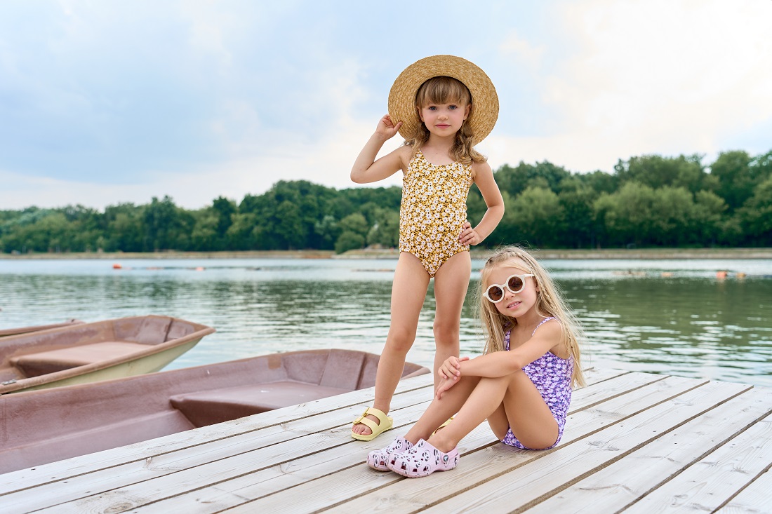 Мальчик c девочкой в купальниках на фоне озера.