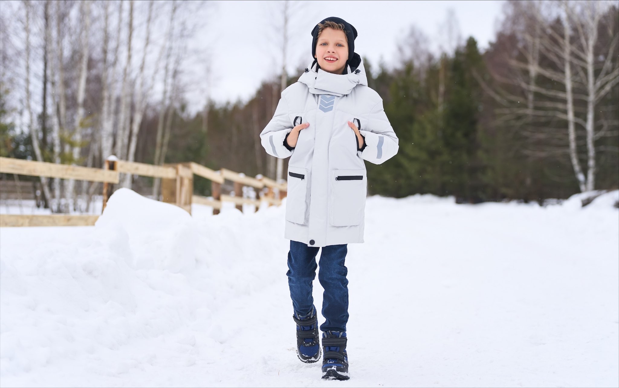 Мальчик гуляет в поле зимой.
