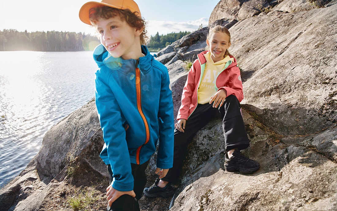Девочка и мальчик на скалах у водоёма.